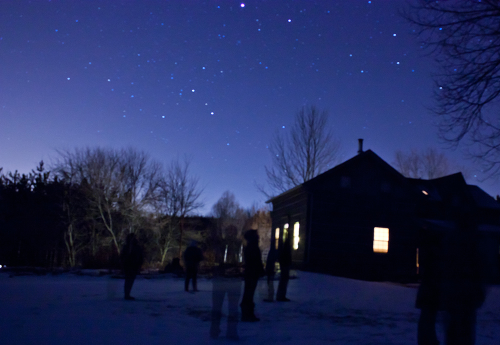 A photo of myself and friends stargazing one night outside of a similar lodge some years later. 